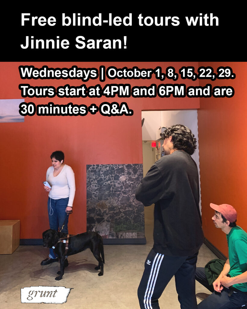 This graphic promotes grunt gallery's blind-led tour series facilitated by Jinnie Saran every Wednesday this October at grunt gallery. There is a black colour-block banner at top, above an image of Jinnie and attendees engaging in a tour of A volar entre rocas within grunt gallery's exhibition space. Bold white text states "Free blind-led tours with Jinnie Saran!" at top with white text outlined in black below that provides details of dates and duration in the area of an upper section of a red-ochre gallery wall. Below text, Jinnie, a young, blind Indo-Canadian artist and writer, is speaking while leading a tour and wears a beige long-sleeve shirt and blue jeans with black boots and rainbow laces. Jinnie has short hair and holds a phone with attached white earbuds and stands facing the camera while slightly oriented left, and holds the harness of her Black Labrador guide dog in her other hand. Two people at right also face left, one person wears all black. Their back is mostly visible and their arms are crossed while another person at bottom right, crouches while wearing a red cap and bright green t-shirt. Both stare intently at Jinnie as she talks. The gallery space is comprised of a polished cement floor and two large red-ochre gallery walls with two washi prints visible, a small excerpt of sky appears at top left, above Jinnie, and a large body-sized print depicting dark lava rock, white mortar, and clothing lines appears immediately behind and to the right of Jinnie and even further to the right is an open doorway with white walls and an exit sign visible in the distance.